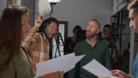 Actores-Con-Guiones-Ensayando-Filmando-Una-Película-O-Un-Video-En-Un-Estudio-Con-Una-Cámara-De-Cine-Y-Un-Equipo-De-Sonido-De-Fondo.-1